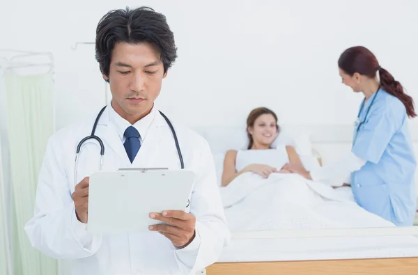 Doctor looking at a chart — Stock Photo, Image