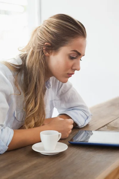 Jolie blonde prenant un café à l'aide de la tablette pc — Photo