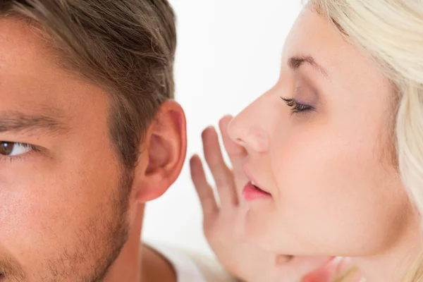 Жінка шепоче секрет у вухо чоловіка — стокове фото