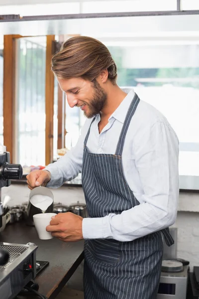 Barista gießt Milch in Tasse Kaffee — Stockfoto