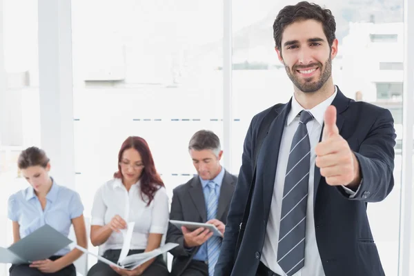 Smiling businessman and his co-workers Stock Photo