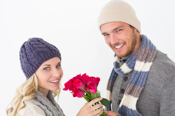 Aantrekkelijke paar in warme kleding bedrijf bloemen — Stockfoto