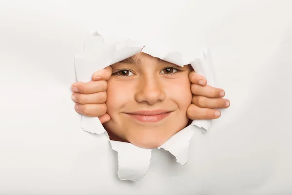 Menina bonito espreitar através de papel — Fotografia de Stock
