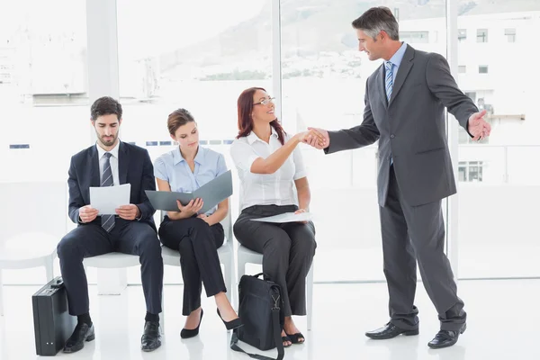 Sonriente hombre de negocios estremeciendo la mano de compañeros de trabajo — Foto de Stock