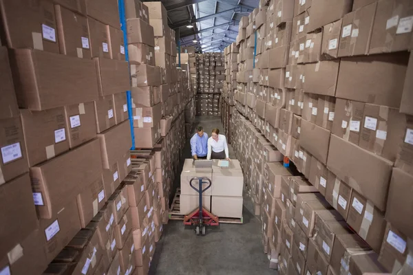 Warehouse team working together with trolley — Stock Photo, Image