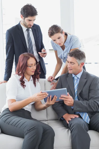 Zakelijke team kijken naar een tablet — Stockfoto