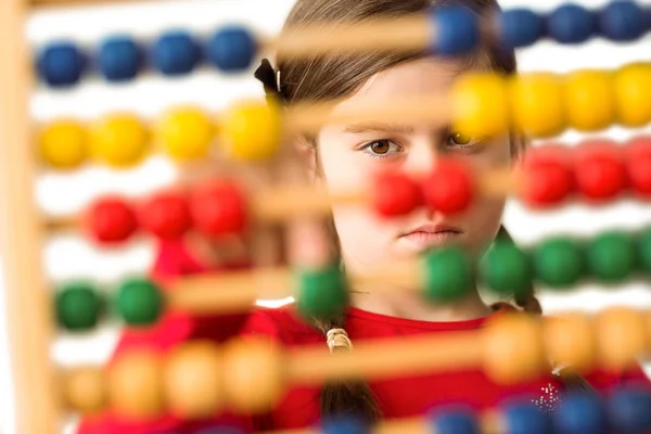 Cute little girl using an abacus — Stock Photo, Image