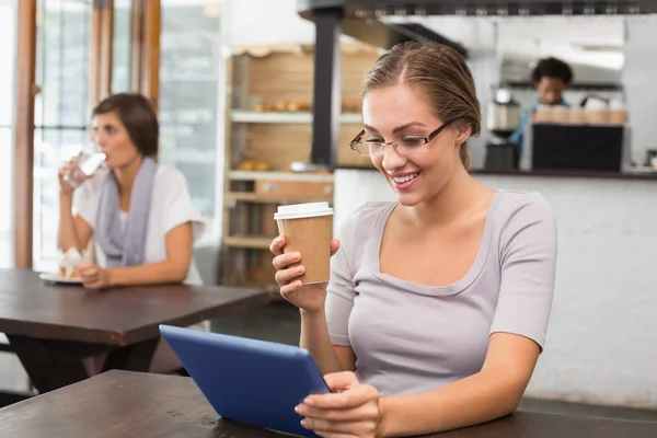 Jolie blonde appréciant un café à l'aide de la tablette pc — Photo