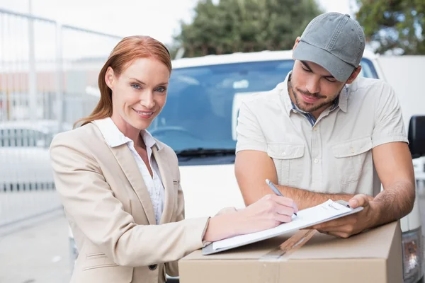 Delivery driver showing where to sign to customer — Stock Photo, Image