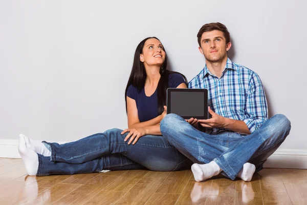 Tablet ile katta oturan genç bir çift — Stok fotoğraf
