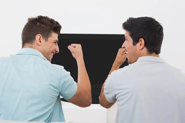 Emocionados aficionados al fútbol viendo la televisión — Foto de Stock