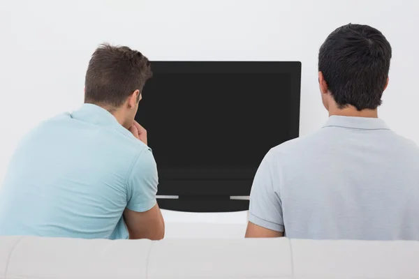 Två fotbollsfans tittar på tv — Stockfoto