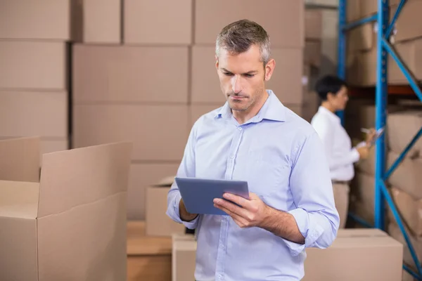 Warehouse manager using his tablet pc — Stock Photo, Image