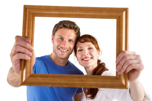 Casal segurando quadro à frente deles — Fotografia de Stock