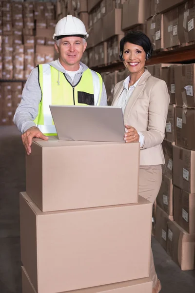 Warehouse worker and manager using laptop — Stock Photo, Image