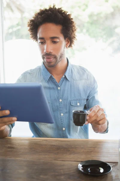 Casual man kopp kaffe medan du använder Tablet PC — Stockfoto