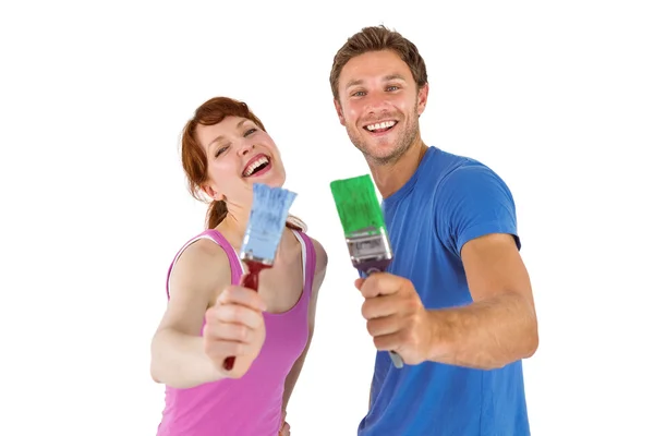 Couple both holding paint brushes — Stock Photo, Image