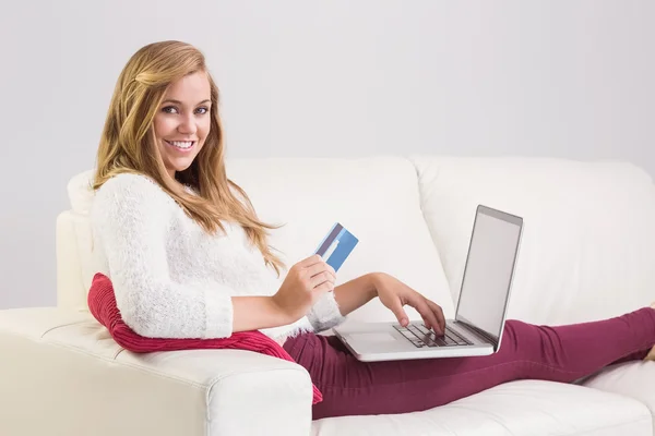 Pretty blonde relaxing on sofa with laptop — Stock Photo, Image
