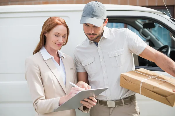 Delivery driver showing where to sign to customer — Stock Photo, Image