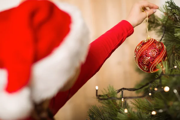 Menina festiva pendurado uma decoração de Natal — Fotografia de Stock