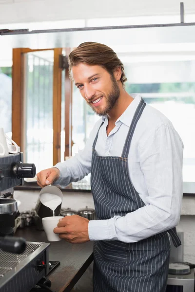 Barista pouring milk into cup of coffee — Stock Photo, Image