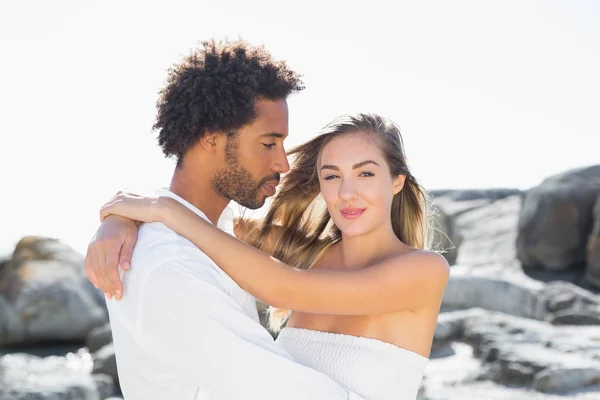 Gorgeous couple embracing at the coast — Stock Photo, Image