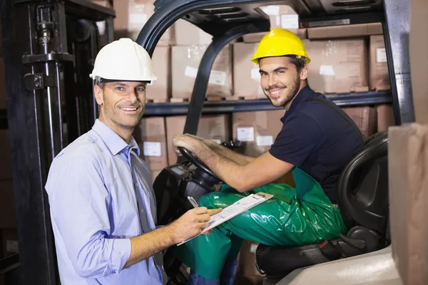 Warehouse manager talking with forklift driver — Stock Photo, Image