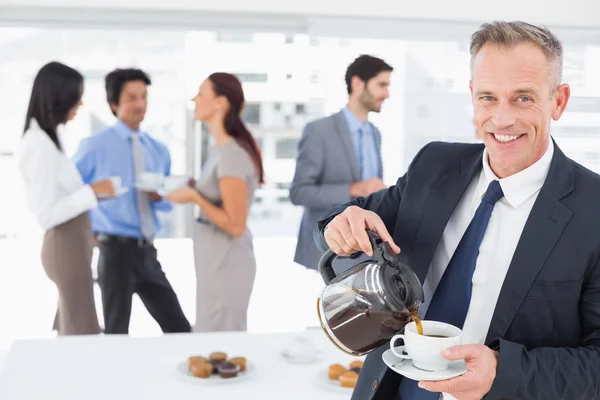 Businessman pouring himself some coffee — Stock Photo, Image
