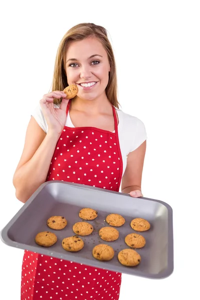 Pretty homemaker showing hot cookies — Stock Photo, Image