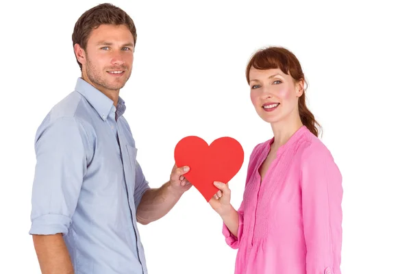 Pareja sosteniendo un corazón rojo — Foto de Stock