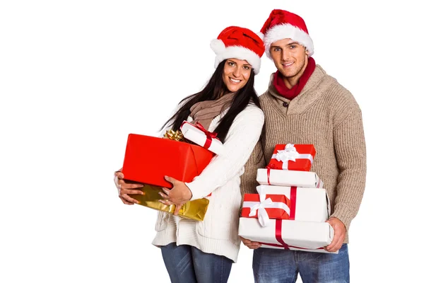 Молодая пара со многими рождественскими подарками — стоковое фото