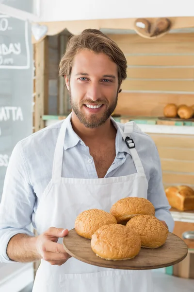 Handsome waiter holding tray of bread rolls — Stock Photo, Image