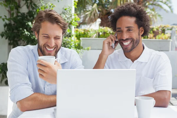 Happy friends enjoying coffee together with laptop — Stock Photo, Image