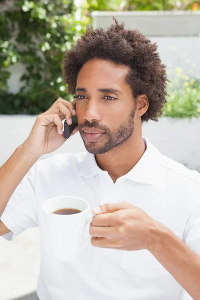 Lächelnder Mann am Telefon beim Kaffee — Stockfoto