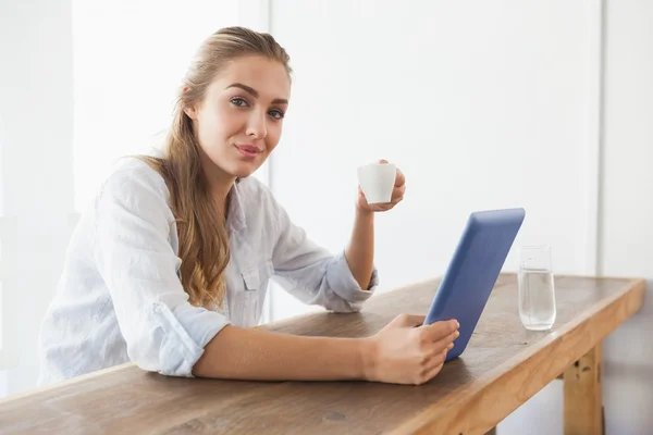 Mooie blonde met koffie tijdens het gebruik van Tablet PC — Stockfoto