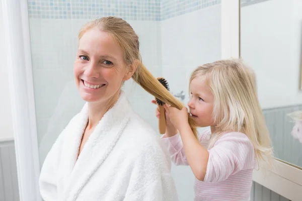 Moeder en dochter haar borstelen — Stockfoto