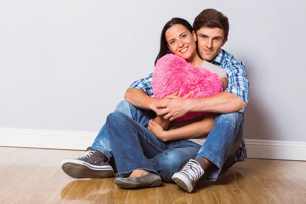 Young couple sitting on floor smiling — Stock Photo, Image