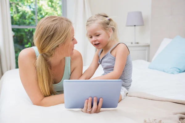 Niña y madre en la cama usando tableta —  Fotos de Stock