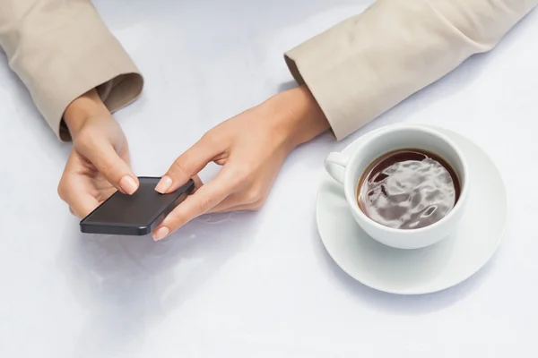 Empresaria usando smartphone con café — Foto de Stock