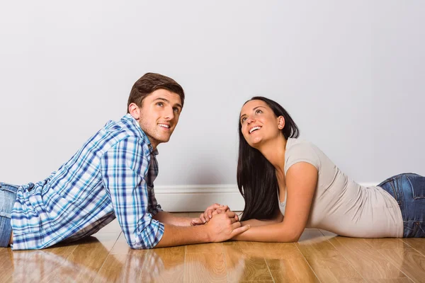 Jovem casal deitado no chão sorrindo — Fotografia de Stock