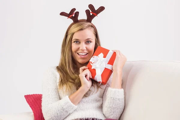 Bionda festiva rilassante sul divano con regalo — Foto Stock