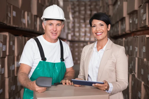 Warehouse worker scanning box with manager — Stock Photo, Image