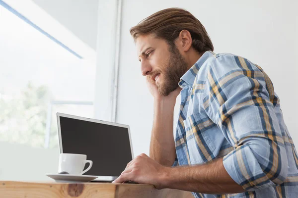 Casual man using laptop having coffee — Stock Photo, Image