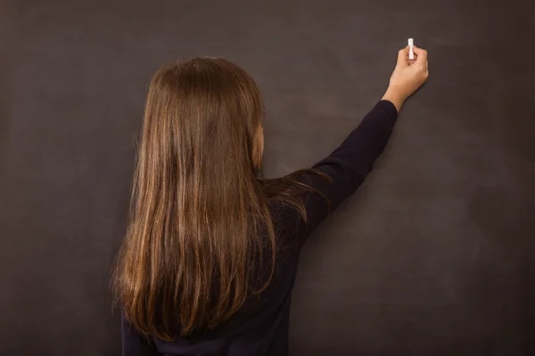 Schattig leerling schrijven op schoolbord — Stockfoto