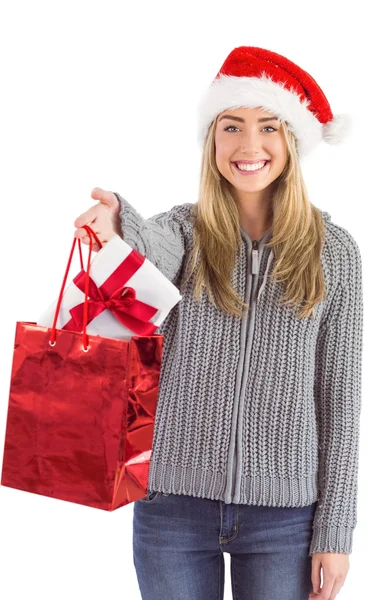 Festive blonde holding christmas gift and bag — Stock Photo, Image