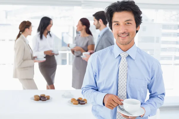 Un hombre de negocios sonriente con una bebida — Foto de Stock