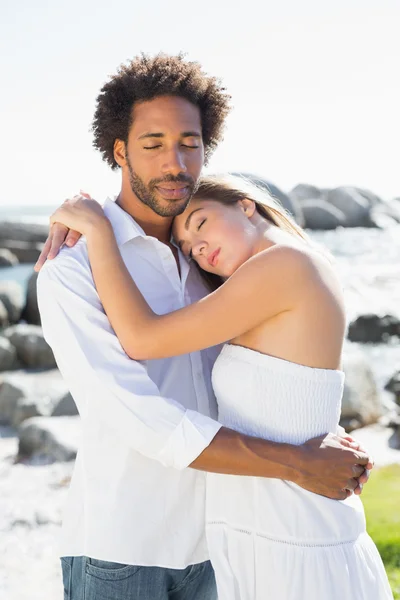 Gorgeous couple embracing at the coast — Stock Photo, Image