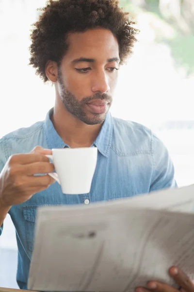 新聞を読みながらコーヒーを持つカジュアルな男 — ストック写真