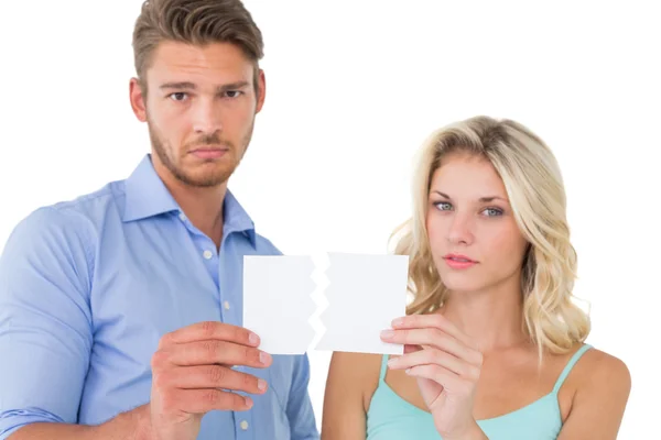 Upset couple holding torn piece of paper — Stock Photo, Image