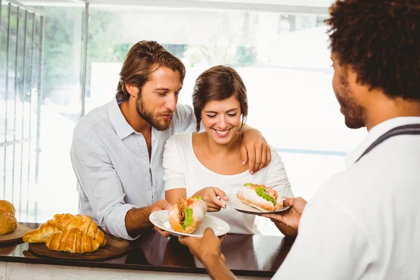 Barista sirviendo a dos clientes felices — Foto de Stock